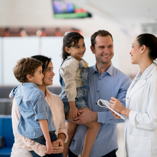 Doctor talking to a happy Latin American family at the office